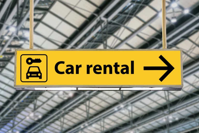 Gelber Wegweiser mit der Aufschrift Car rental für Mietwagen